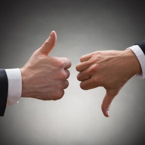 40870643 - close-up of two businesspeople hands showing thumb up and thumb down sign